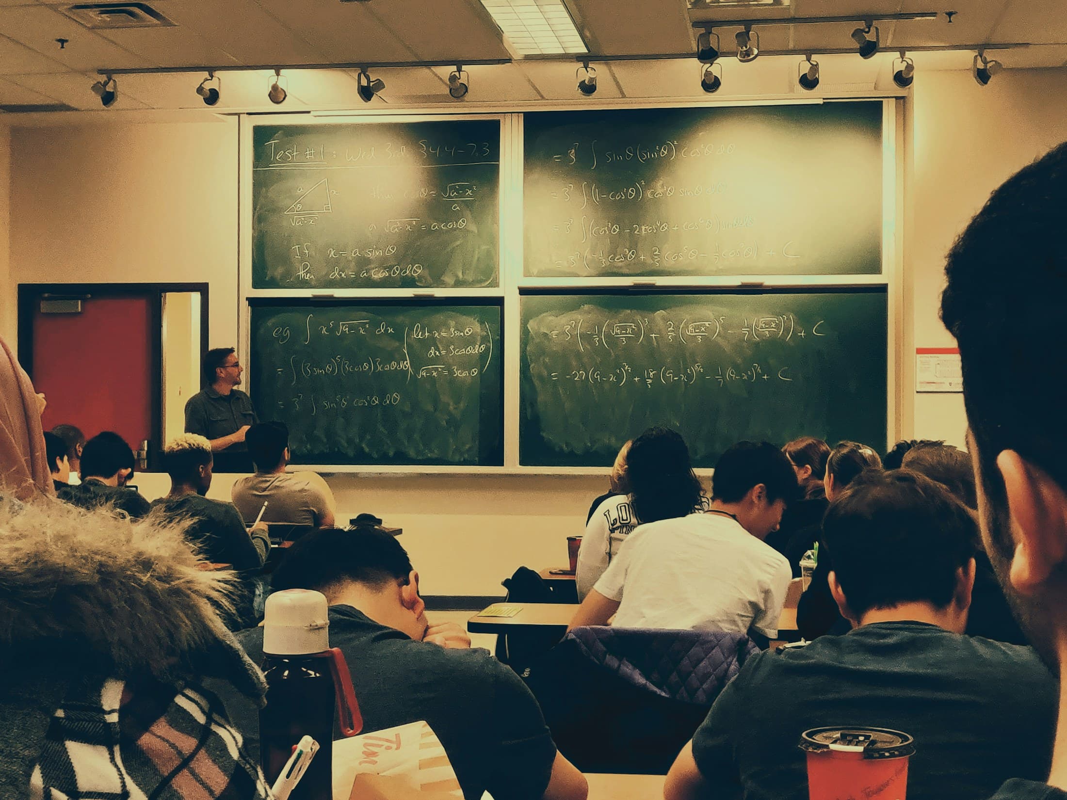 A classroom working through calculations on large chalkboards